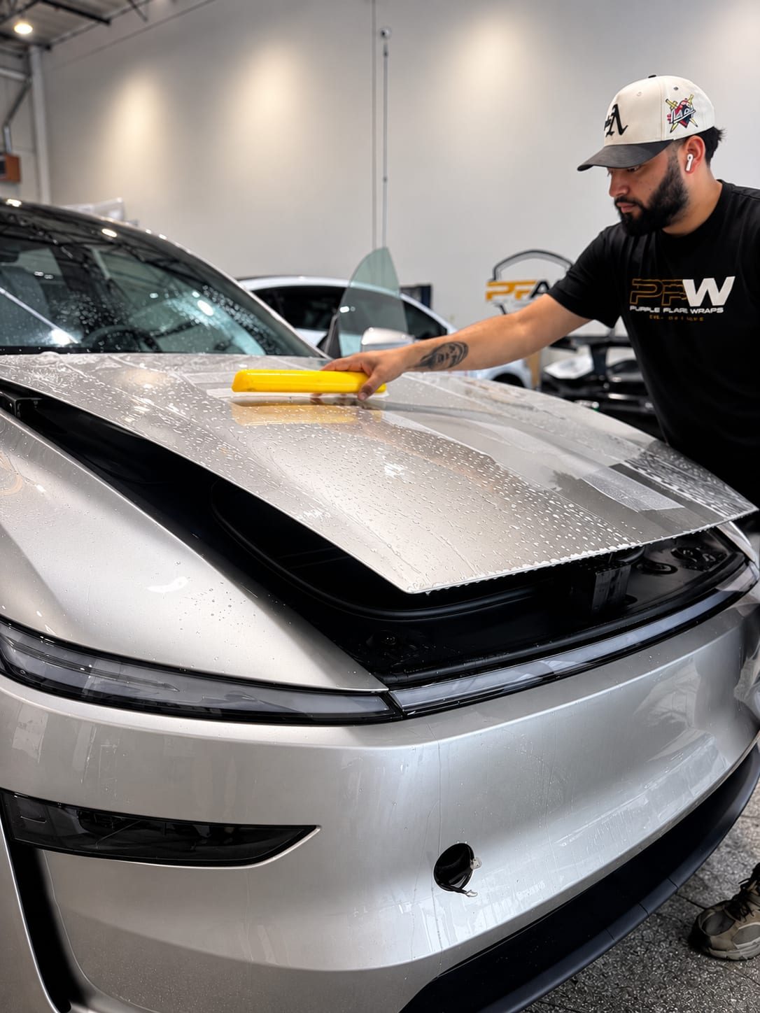 Purple Flare Installer Squeegeeing Paint Protection Film Onto A Hood
